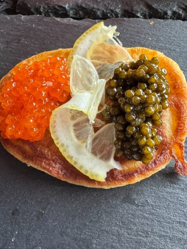 Delikate Häppchen mit Rotem Kaviar, grünem Kaviar und Zitronenscheiben.